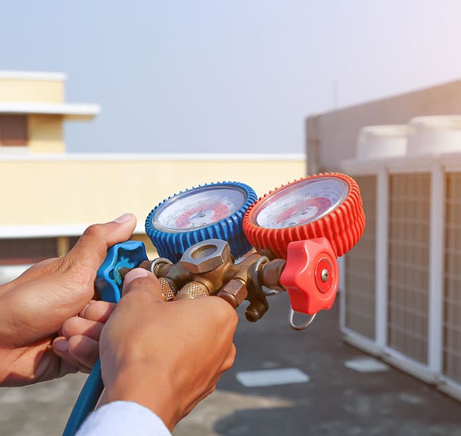 Someone holding a pressure gang tester on the top of the roof