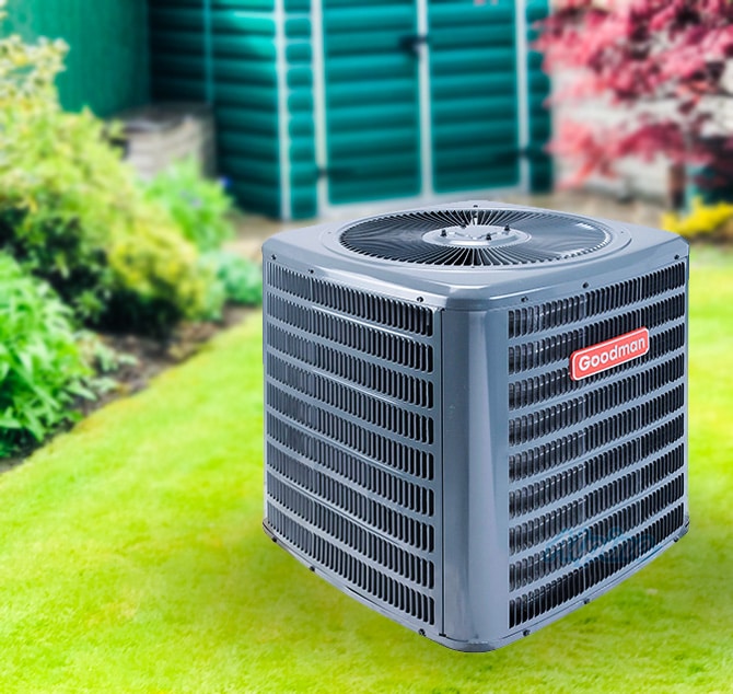 Goodman air condition unit on green grass with colorful plants in the background